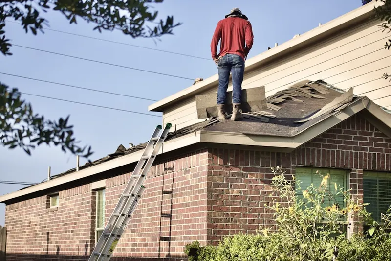 Professional roofer working on a residential roof in Roser Park